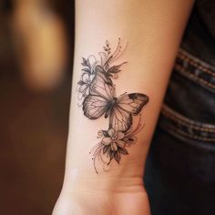 a woman's arm with a butterfly tattoo on the left side of her wrist