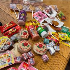 many candy bars and candies are on the table with some lollipops