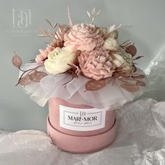 a pink hat with flowers in it sitting on a table