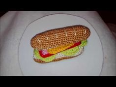 a crocheted hot dog on a white plate