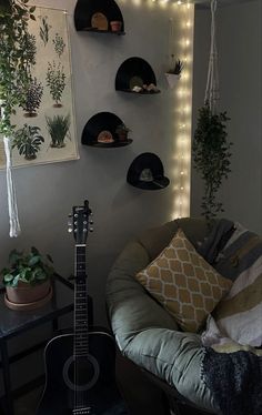 a guitar is sitting on a couch in front of a wall with potted plants