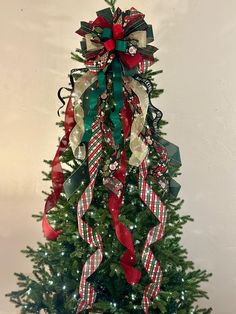 a christmas tree decorated with ribbons and bows