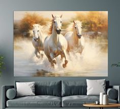 three white horses running in the water on a wall above a couch and coffee table