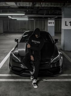 a man sitting on the hood of a car