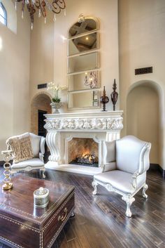 a living room with two chairs and a fire place in the middle of the room