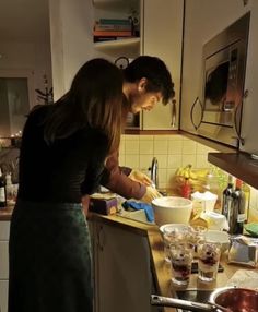 a man and woman are preparing food in the kitchen