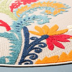 a multicolored rug with flowers and leaves on the bottom is shown in close up