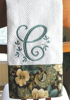 an embroidered monogrammed towel hanging on a chair with the letter s in it