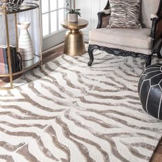 a zebra print rug in a living room with a chair and side table on the floor