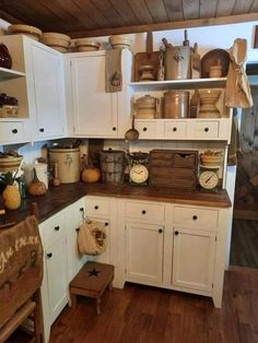 an old fashioned kitchen with white cabinets and wood flooring is pictured in this image