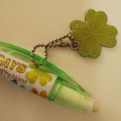 a green pen with a shamrock shaped keychain attached to it