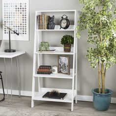 a white book shelf with books and plants on it