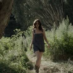 a woman walking down a path in the woods