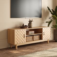 an entertainment center with a large flat screen tv mounted on the wall and wicker baskets in front of it