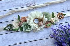 flowers are arranged on the side of a white wooden table next to lavenders and a ribbon