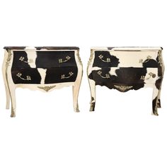 two black and white cow hide chests with gold trimmings, one on each side