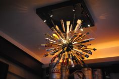 a chandelier made out of wine bottles is hanging from the ceiling