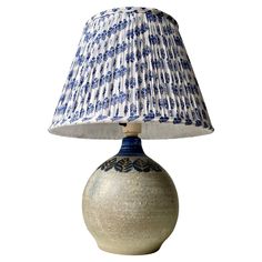 a blue and white vase with a lamp on it's side, isolated against a white background