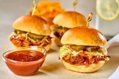 three pulled pork sliders with cole slaw and ketchup on the side