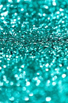 a close up view of some glitter on a table top with blue and green colors