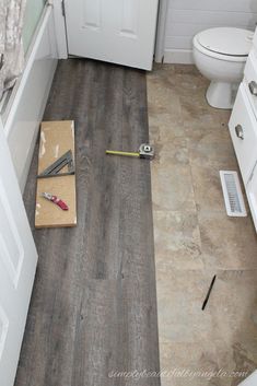 a bathroom with wood flooring and white cabinets