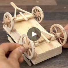 a person is playing with a wooden toy car