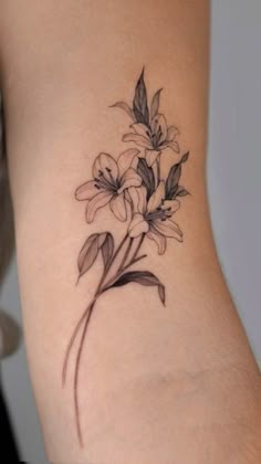 a woman's lower back tattoo with flowers on her left side ribcage