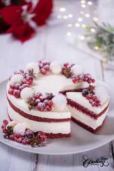 a white plate topped with a cake covered in frosting and pomegranates