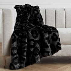 a couch with a black and grey animal print blanket sitting on it's side