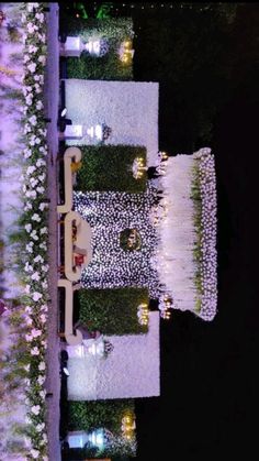 an aerial view of the lawn at night with lights on it and flowers all around