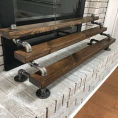 two wooden benches sitting on top of a brick fireplace