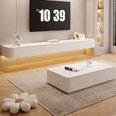 a modern living room with white furniture and large screen tv on the wall above it