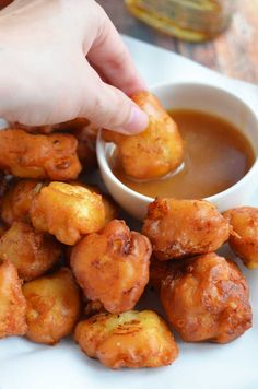 a person dipping sauce on some fried food