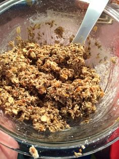 a bowl filled with granola sitting on top of a table next to a person