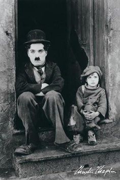 a black and white photo of a man with a child sitting in front of him