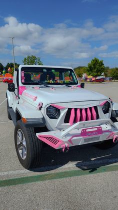 a white and pink jeep parked in a parking lot