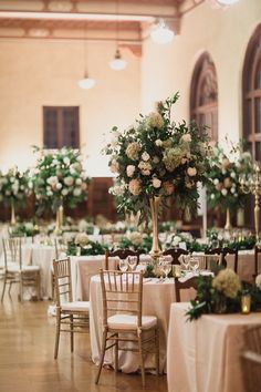 the tables are set with white and green flowers