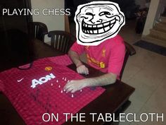 a man sitting at a table with a manchester shirt on it