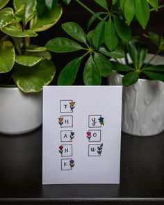 a card that says thank you and has flowers on it next to potted plants