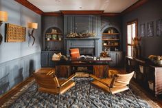 a living room filled with furniture and a fire place next to a desk on top of a rug