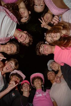 a group of young people standing in a circle with their hands up to the camera