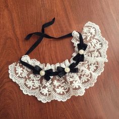 a black and white lace collar on a wooden floor