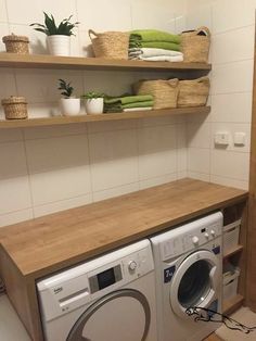 a washer and dryer in a small room with open shelving on the wall