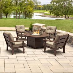 an outdoor fire pit with chairs around it