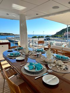 the dining table is set with plates and silverware on it, overlooking the water