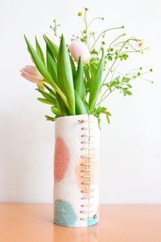 a vase filled with flowers on top of a wooden table