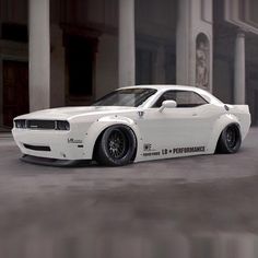 a white sports car parked in front of an old building with columns on the sides