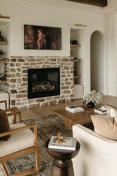 a living room filled with furniture and a fire place in front of a stone fireplace