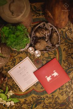 the wedding stationery is laid out on top of an ornately patterned tablecloth