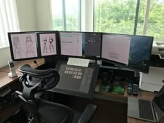 three computer monitors sitting on top of a desk next to a keyboard and monitor screen